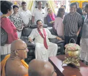  ??  ?? Newly appointed Sri Lankan Prime Minister Mahinda Rajapaksa, center, sits to talk with supporters at a Buddhist temple in Colombo, Sri Lanka. Two men each are claiming to be the country’s prime minister.