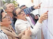  ?? [AP PHOTO] ?? Voters look for their assigned polling stations Sunday during the presidenti­al election in Bogota, Colombia.