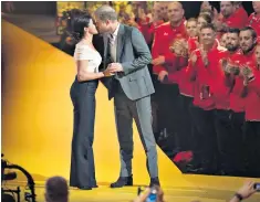  ?? ?? The Duchess, right, applauds her husband at the games. Left, the couple kiss on stage