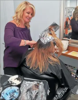  ?? PHOTO COURTESY OF SALON EVOLVE ?? Salon Evolve owner Kim McQuillan colors a client’s hair at her Limerick salon. The foils, as well as left over color are now being recycled by Salon Evolve as part of a salon industry recycling program. Salon Evolve is Green Circle Salon certified, and is recycling its salon waste including hair clippings, left over product, plastic bottles, color tubes and broken styling tools.