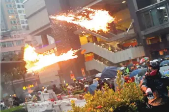  ??  ?? An anti-extraditio­n bill protester throws a Molotov cocktail as protesters clash with riot police during a rally to demand democracy and political reforms, at Tsuen Wan Sunday night.