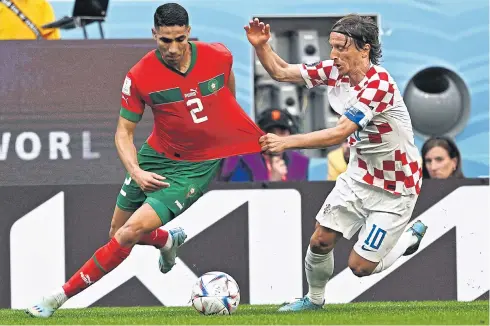  ?? AFP ?? Croatia’s Luka Modric, right, vies with Morocco’s Achraf Hakimi during their World Cup match at the Al Bayt Stadium yesterday.