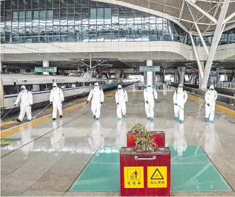  ??  ?? La estación de trenes de la provincia de Hubei, cuya capital es Wuhan, es desinfecta­da por un equipo especial. Los pobladores sanos podrán salir desde hoy para trabajar. (AFP)