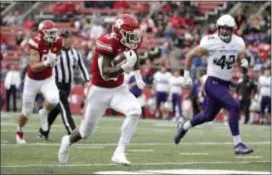  ?? JULIO CORTEZ — THE ASSOCIATED PRESS ?? Rutgers running back Isaih Pacheco, center, runs for a touchdown as Northweste­rn linebacker Paddy Fisher, right, tries to stop him.