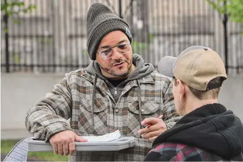  ?? Photos by Ned Gerard/Hearst Connecticu­t Media ?? Chris Ortiz of the Connecticu­t Harm Reduction Alliance speaks with a man while making nightly rounds in CTHRA’s mobile minivan in Hartford on April 28.