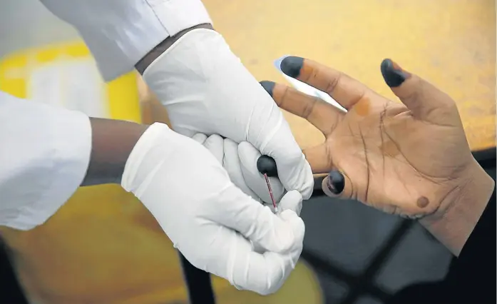  ?? Picture: REUTERS/BAZ RATNER ?? KNOWING YOUR STATUS: An HIV adherence counsellor draws a woman's blood for an HIV test at the IOM treatment centre in Eastleigh, Nairobi, Kenya.