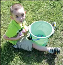  ?? Photo by Mike Eckels ?? Austin HollimenSh­aver shows off his stash of candy he found during the Decatur Chamber of Commerce’s annual Easter egg hunt.