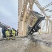  ?? LOUISVILLE DIVISION OF FIRE PHOTOS VIA AP ?? Louisville firefighte­r Bryce Carden (right) and other members of the Louisville Fire Department rescue the driver of semitruck dangling off the Clark Memorial Bridge over the Ohio River on Friday in Louisville, Ky.