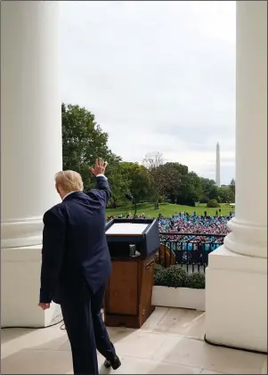  ?? The Associated Press ?? BLUE ROOM BALCONY: President Donald Trump waves from the Blue Room Balcony of the White House to a crowd of supporters on Oct. 10 in Washington. The most improbable of presidents, Trump reshaped the office and shattered its centuries-old norms and traditions while dominating the national discourse like no one before.