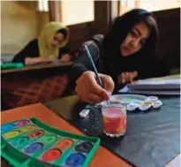  ??  ?? An Afghan student practices on a miniature during a calligraph­y class.