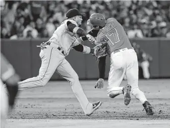  ?? Marcio Jose Sanchez / Associated Press ?? The Angels' Shohei Ohtani is tagged out by Astros third baseman Yuli Gurriel after being caught in a rundown between second and third during the second inning Tuesday night.