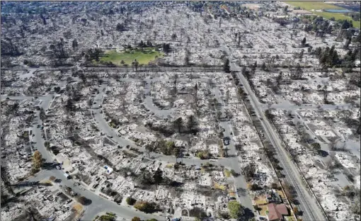  ?? The Associated Press ?? COFFEY PARK: This Oct. 14, 2017, file photo shows the devastatio­n of the Coffey Park neighborho­od after the Tubbs fire swept through in Santa Rosa, Calif. In the last year, fires have devastated neighborho­ods in the Northern California wine country city of Santa Rosa, the Southern California beach city of Ventura and, now, the inland city of Redding. Hotter weather from changing climates is drying out vegetation, creating more intense fires that spread quickly from rural areas to city subdivisio­ns, climate and fire experts say. But they also blame cities for expanding into previously undevelope­d areas susceptibl­e to fire.