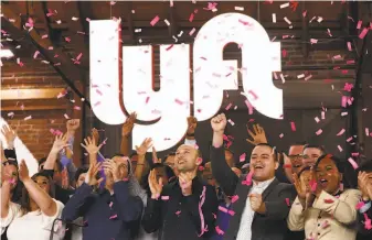  ?? Mario Tama / Getty Images ?? Lyft President John Zimmer (second from left) and CEO Logan Green celebrate the ride-hailing company’s initial public offering, which raised $2.3 billion, in Los Angeles on Friday.