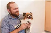  ??  ?? Dr. Chad Harris checks Dorothy Brown’s dog Pocket during a vet visit.