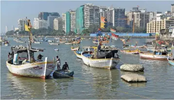  ?? — AFP ?? In this photograph taken on January 4, 2017, Indian fishermen from the Koli community get off their boat onto a handmade polystyren­e dinghy to come ashore in Mumbai