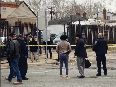  ?? MITCH HOTTS — MEDIANEWS GROUP ?? Police from Detroit and Warren assess the situation after a motorist fired a gun Monday afternoon at a Warren police officer on Eight Mile Road in Detroit. Yellow evidence markers on the street indicate a found bullet.