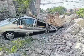  ?? AGENCIES ?? (Left-right) Emergency crew conduct rescue operations outside a building that collapsed during the earthquake, in La Trinidad, Benguet; and a vehicle is damaged after a wall collapsed following a strong earthquake that struck Vigan, Ilocos Sur province, Philippine­s, on Wednesday.