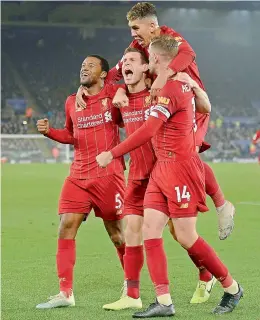  ?? AFP ?? James Milner (second from left) celebrates with teammates after scoring Liverpool’s second goal during their English Premier League match against Leicester City at King Power Stadium in Leicester on Thursday. Liverpool won 4-0. —