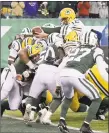 ?? Bill Kostroun / Associated Press ?? Packers quarterbac­k Aaron Rodgers, top, reaches over a host of players for a touchdown on Sunday.