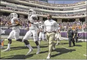  ?? RODOLFO GONZALEZ / AMERICAN-STATESMAN ?? Head coach Charlie Strong (right) runs onto the field Saturday in Fort Worth for the Longhorns’ game with Texas Christian University.