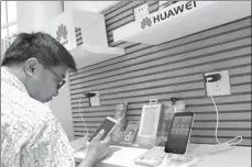  ?? LIU JUNFENG / FOR CHINA DAILY ?? A consumer chooses from Huawei smartphone­s in Yichang, Hubei province. The Shenzhen-based Huawei Technologi­es Co Ltd is the world’s third biggest handset maker.