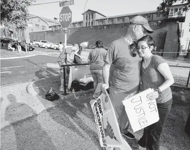  ?? Melissa Phillip photos / Houston Chronicle ?? Peter Charlap of Poughkeeps­ie, N.Y., and Marie Brignac of Houston embrace as they and other protesters prepare to leave the Huntsville Unit after the execution of Christophe­r Anthony Young.