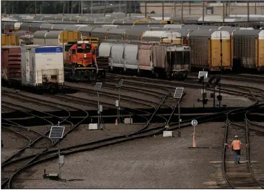  ?? (AP) ?? A worker walks along tracks at a BNSF rail yard in Kansas City in September. Six smaller railroad unions have now approved their agreements with the major freight railroads, but all 12 unions must sign on to avoid a strike.