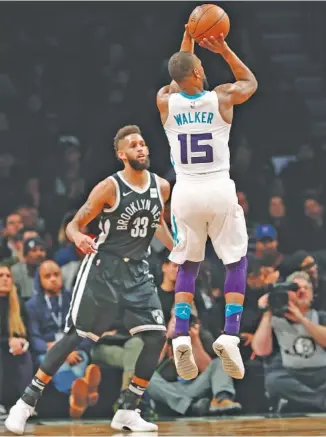  ?? THE ASSOCIATED PRESS ?? Charlotte Hornets guard Kemba Walker shoots a 3-pointer as Brooklyn Nets guard Allen Crabbe watches during their game March 21 in New York. The NBA’s record for total 3s made in a season was broken Friday, the sixth straight year that has happened.