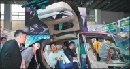  ?? CHEN CHUHONG / CHINA NEWS SERVICE ?? Visitors check out a kiosk featuring new energy vehicles on Tuesday at the 135th China Import and Export Fair, also known as the Canton Fair, in Guangzhou, Guangdong province.
