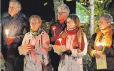  ?? FOTO: KURT GLÜCKLER ?? Die Kirchenglo­cken Spaichinge­ns läuteten fünf Minuten lang um 19 Uhr am Freitag. Die Teilnehmer der ökumenisch­en Gedenkfeie­r hielten Kerzen in den Händen.