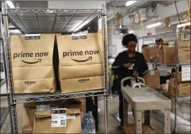  ?? MARK LENNIHAN / AP 2017 ?? Prime Now orders are ready for delivery at the Amazon warehouse in New York. Details on the health care company announced Tuesday with Berkshire and JPMorgan are slim. But experts say Amazon has the ability to shake up the industry: It already has a...