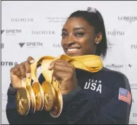  ?? The Associated Press ?? HEAVY MEDAL: Simone Biles of the United States shows her five gold medals she won at the Gymnastics World Championsh­ips in Stuttgart, Germany, Sunday.