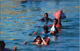  ?? Fernando Llano / Associated Press ?? Migrants, many from Haiti, wade across the Rio Grande from Del Rio, Texas, to return to Ciudad Acuna, Mexico, on Monday to avoid deportatio­n from the U.S. The U.S. is flying Haitians camped in a Texas border town back to their homeland and blocking others from crossing the border from Mexico.