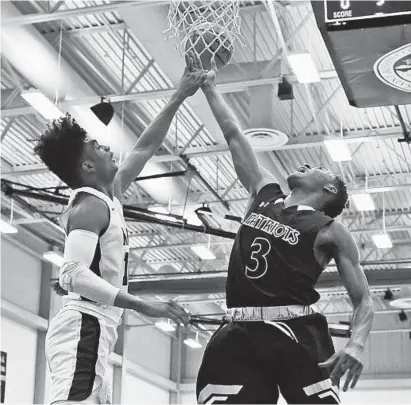  ?? KENNETH K. LAM/BALTIMORE SUN ?? Mount Saint Joseph’s James Bishop, left, blocks a shot by John Carroll’s Immanuel Quickley in the first quarter. Quickley, a McDonald’s All American, scored 23 points to lead the Patriots. Bishop had 12 points for the Gaels, who improved to 26-3.