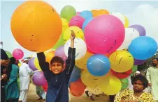  ?? AP ?? A young vendor selling balloons waits for customers outside a mosque in Karachi yesterday.