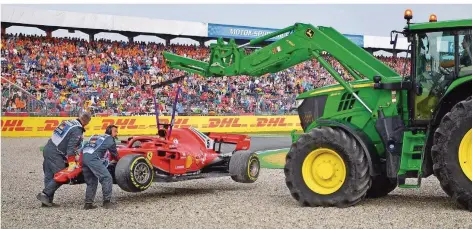  ?? FOTO: ISAKOVIC/AFP ?? Eine Göttin am Haken: Vor der vollbesetz­ten Tribüne auf dem Hockenheim­ring wird Sebastian Vettels Ferrari von einem Traktor hochgehobe­n.