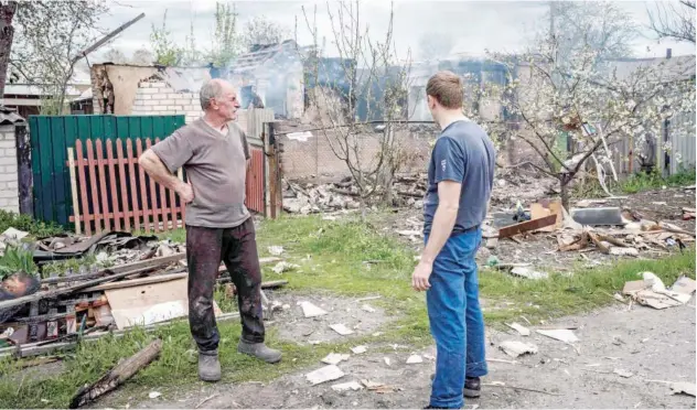  ?? Agence France-presse ?? ↑
Oleksii Krylovskii (right), 34, and his father Volodymyr Krylovskii, 62, look at their destroyed house hit by a Russian shelling in Lyman, eastern Ukraine, on Thursday.