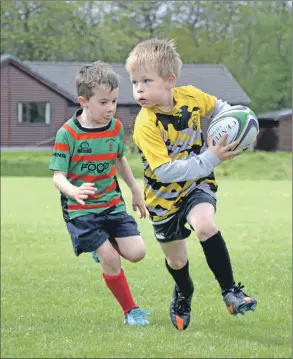  ?? Picture: Stephen Day ?? Determinat­ion written all over the face of young Etive Vikings Aidan Lawrie as he runs past Oban Lorne’s Ruan Kemp.