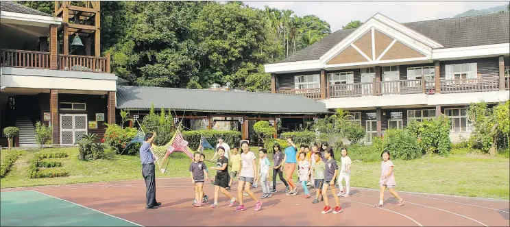  ??  ?? Children exercise at the Chin-shuei primary school, which was rebuilt after being badly damaged by a 1999 earthquake that devastated Jhongliao, Taiwan.