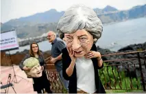  ?? PHOTOS: REUTERS ?? A protester removes her heavy mask depicting Britain’s Prime Minister Theresa May after a demonstrat­ion organised by Oxfam in Giardini Naxos, Sicily, Italy.