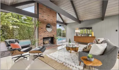  ?? PHOTOS BY CHRIS FOX ?? The living room features a floor-to-ceiling brick fireplace and glass walls.