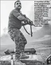  ??  ?? A member of the Iraqi government forces takes a position on top of a vehicle on the outskirts of the Qayyarah area, south of Mosul, during an operation against Islamic State to retake the main hub city.