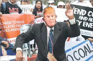  ?? AFP photo ?? An environmen­tal activist wearing a face-mask depicting Trump takes part in a demonstrat­ion in front of the United Nations building in Bangkok. —