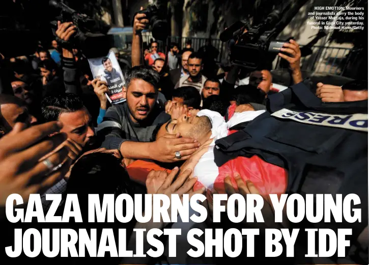  ??  ?? HIGH EMOTION: Mourners and journalist­s carry the body of Yasser Murtaja, during his funeral in Gaza City yesterday. Photo: Mahmud Hams/Getty