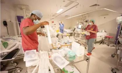  ??  ?? NHS staff prepare a temporary Covid ward in a London hospital in late December 2020. Photograph: Graeme Robertson/The Guardian