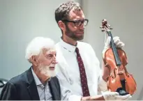  ?? THE COMMERCIAL APPEAL FILE ?? Stax founder Jim Stewart, left, stands with Jeff Kollath, executive director of the Stax Museum of American Soul Music, while showing off Stewart’s fiddle during a July 25, 2018, ceremony where Stewart donated his fiddle to the Stax Museum of American Soul Music.