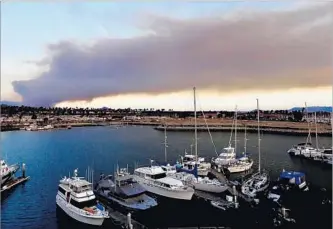  ?? Al Seib Los Angeles Times ?? SMOKE billows from the Thomas fire in the Santa Paula and Fillmore areas, as seen from Ventura Harbor on Thursday at sunset. This week’s wind-driven fires are forever changing lives yet again.