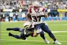 ?? Kevork Djansezian / Getty Images ?? New England’s Damien Harris runs with the ball while being tackled by the Chargers’ Drue Tranquill in the Pats’ 27-24 win on Sunday. Harris had 23 carries for 80 yards.