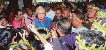  ?? [FOTO MUHD ASYRAF SAWAL/BH] ?? Najib disambut orang ramai ketika hadir pada Perasmian Serentak Persidanga­n Tahunan Cawangan dan Sayap-sayap UMNO Bahagian di Pekan, semalam.