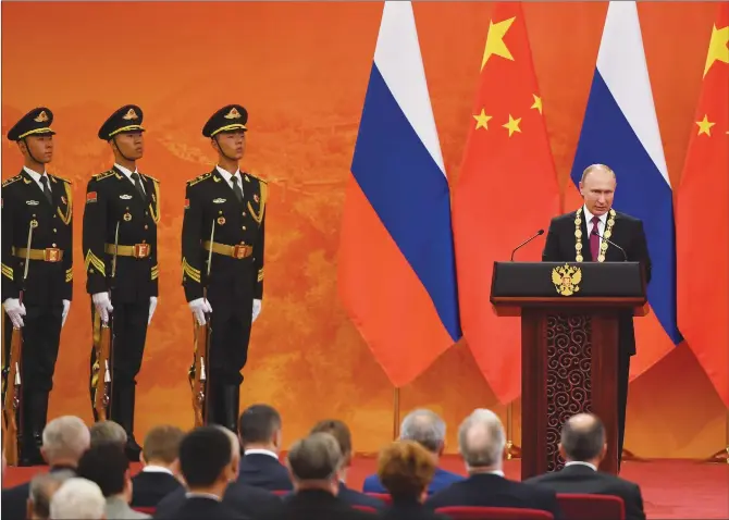  ?? Photos: IC/ Xinhua ?? Russian President Vladimir Putin (right) speaks after being presented with the Friendship Medal of the People’s Republic of China by Chinese President Xi Jinping at the Great Hall of the People in Beijing on Friday. Right: The friendship medal